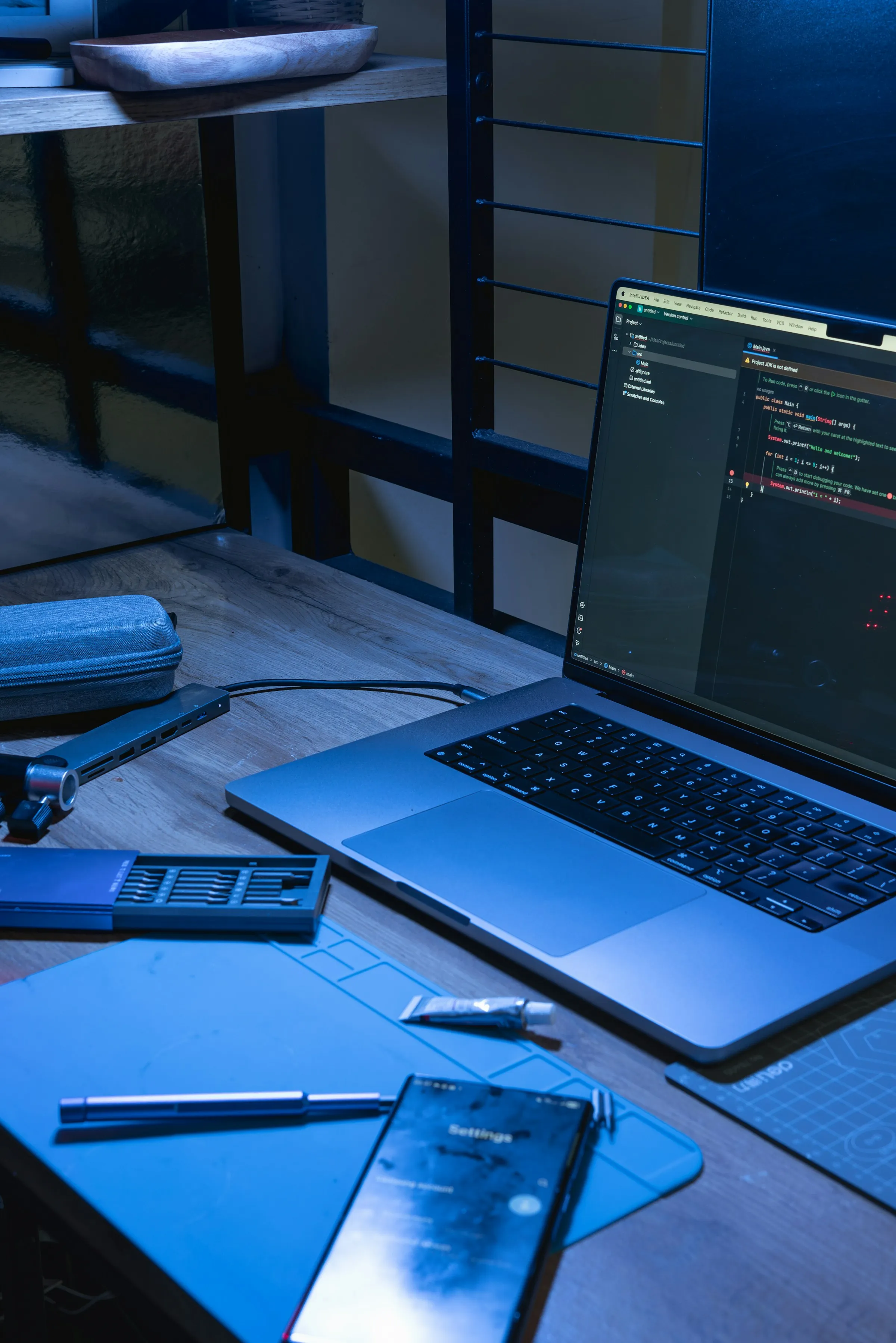 Developer workspace with laptop, tools and engineering notes.