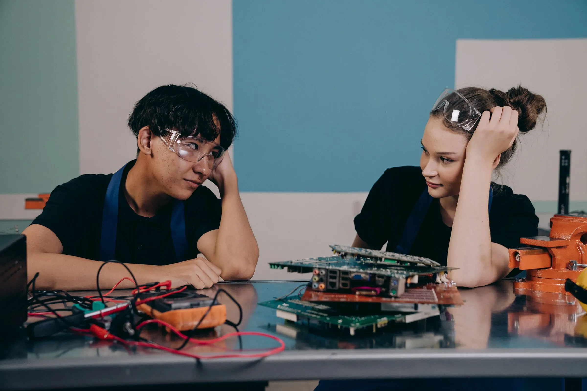 Two engineers collaborating at an electronics workbench.